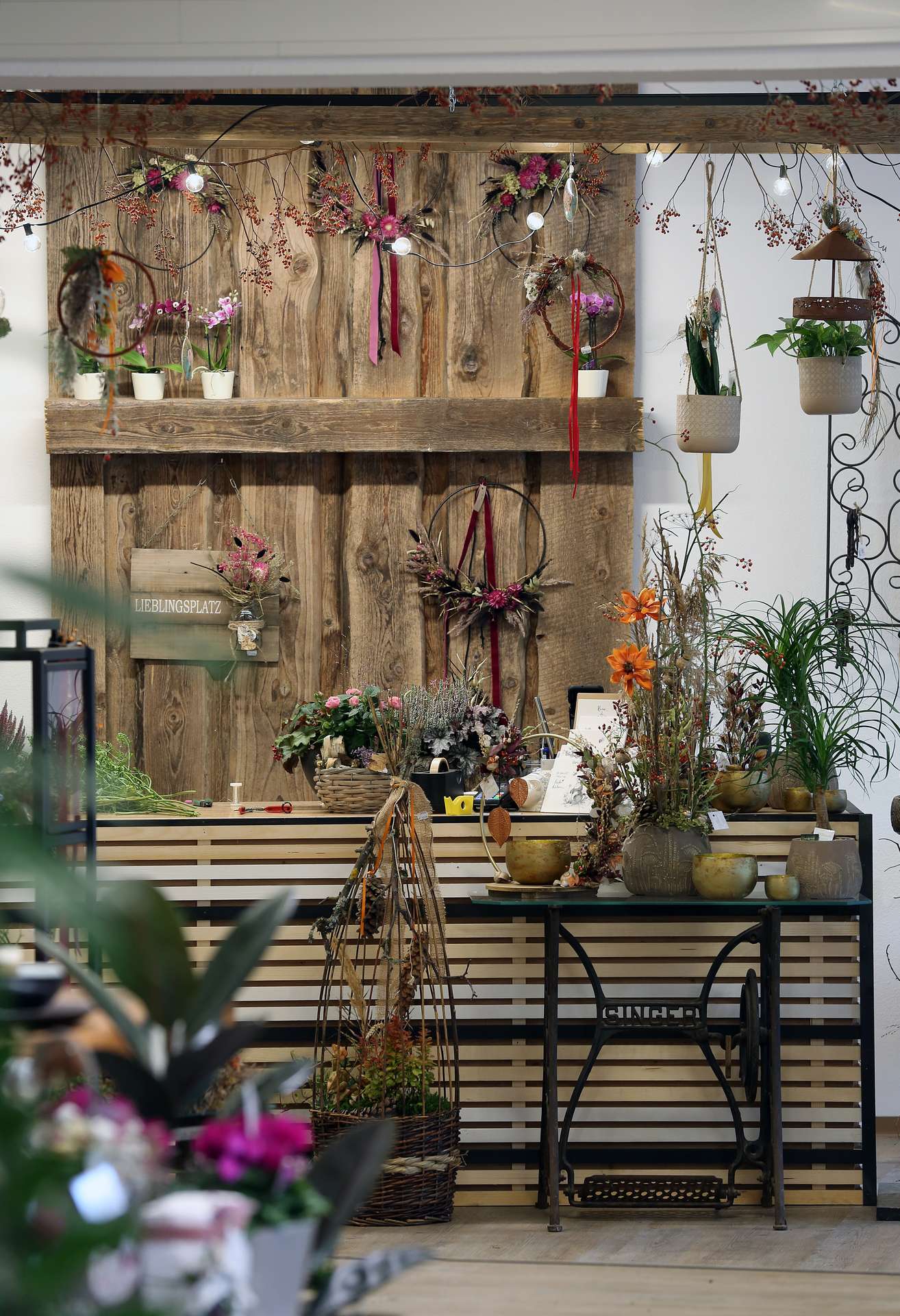 Lieblingsplatz im Geschäft der Floralen Manufaktur mit Kränzen und Pflanzen