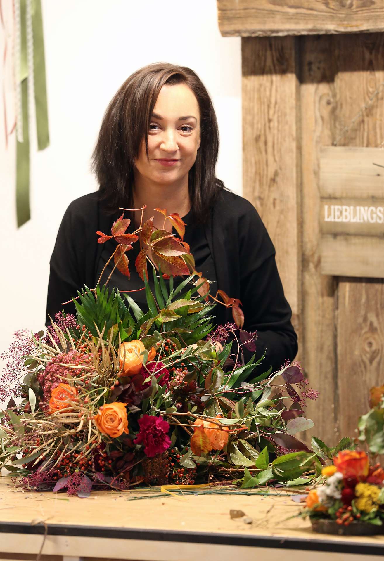 Floristin der Floralen Manufaktur bindet ein herbstliches Gesteck